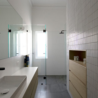 This is an example of a contemporary 3/4 bathroom in Perth with light wood cabinets, a curbless shower, white tile, mosaic tile, white walls, slate floors, a vessel sink, grey floor, a hinged shower door, white benchtops and flat-panel cabinets.