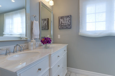 Diseño de cuarto de baño clásico renovado de tamaño medio con armarios tipo mueble, puertas de armario blancas, encimera de mármol, baldosas y/o azulejos grises y paredes verdes