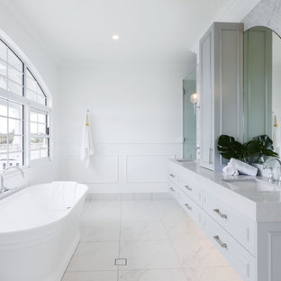 Beach style bathroom in Gold Coast - Tweed with raised-panel cabinets, grey cabinets, a freestanding tub, gray tile, white walls, an undermount sink, white floor, grey benchtops and a double vanity.