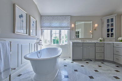 Mid-sized elegant master marble floor bathroom photo in New York with raised-panel cabinets, gray cabinets, a two-piece toilet, beige walls, an undermount sink and marble countertops