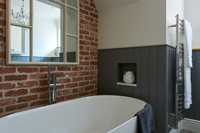 ハートフォードシャーにある中くらいなカントリー風のおしゃれな子供用バスルーム (家具調キャビネット、置き型浴槽、グレーの壁) の写真