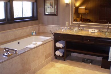 Mid-sized elegant master beige tile and marble tile marble floor and beige floor bathroom photo in Milwaukee with raised-panel cabinets, dark wood cabinets, an undermount tub, beige walls, a vessel sink and granite countertops