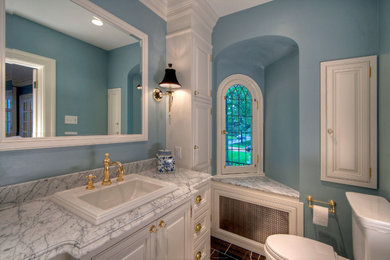 Corner shower - mid-sized traditional master multicolored tile and stone tile marble floor corner shower idea in St Louis with a drop-in sink, raised-panel cabinets, white cabinets, marble countertops, a two-piece toilet and blue walls
