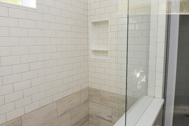 デンバーにあるトランジショナルスタイルのおしゃれな浴室 (セラミックタイルの床、マルチカラーの床、ダブルシャワー、サブウェイタイル、白い壁、開き戸のシャワー、白いタイル) の写真