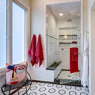 Klassisk inredning av ett en-suite badrum, med vit kakel, tunnelbanekakel, mosaikgolv, en dusch i en alkov, beige väggar, flerfärgat golv och dusch med gångjärnsdörr