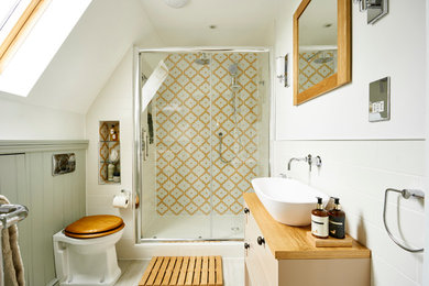 Пример оригинального дизайна: маленькая главная ванная комната в классическом стиле с плоскими фасадами, бежевыми фасадами, открытым душем, унитазом-моноблоком, разноцветной плиткой, керамической плиткой, белыми стенами, полом из керамической плитки, раковиной с несколькими смесителями, столешницей из дерева, бежевым полом, душем с раздвижными дверями и бежевой столешницей для на участке и в саду