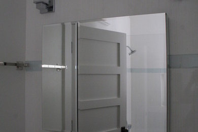 Mid-sized transitional master blue tile, white tile and porcelain tile laminate floor and gray floor tub/shower combo photo in Other with a one-piece toilet, white walls, an integrated sink, solid surface countertops, a hinged shower door and white countertops
