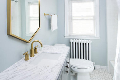 Example of a mid-sized transitional master porcelain tile and white floor bathroom design in Minneapolis with flat-panel cabinets, black cabinets, a two-piece toilet, blue walls, an undermount sink, marble countertops and gray countertops