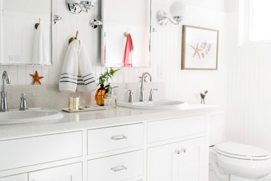 Ejemplo de cuarto de baño marinero con armarios estilo shaker, puertas de armario blancas, paredes blancas, lavabo encastrado, suelo azul y encimeras blancas
