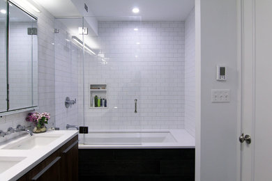 Tub/shower combo - mid-sized modern master white tile and ceramic tile porcelain tile tub/shower combo idea in New York with an undermount sink, dark wood cabinets, white walls, a wall-mount toilet, flat-panel cabinets, quartzite countertops and an undermount tub