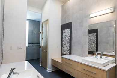 Trendy gray tile bathroom photo in Other with a vessel sink, flat-panel cabinets, light wood cabinets and white walls