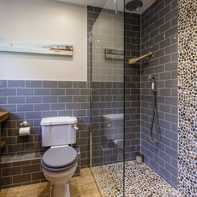 Inspiration for a coastal master gray tile and subway tile ceramic tile bathroom remodel in Cambridgeshire with furniture-like cabinets, dark wood cabinets, a one-piece toilet, gray walls, a drop-in sink and wood countertops
