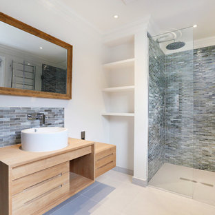 Ispirazione per una stanza da bagno con doccia minimal con ante lisce, ante in legno chiaro, doccia alcova, piastrelle a listelli, pareti bianche, lavabo a bacinella, top in legno, piastrelle grigie, porta doccia a battente e top beige