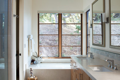 Cette photo montre une salle de bain principale tendance en bois brun de taille moyenne avec un lavabo encastré, un placard à porte plane, un plan de toilette en marbre, une baignoire encastrée, un carrelage bleu, un carrelage de pierre, un mur blanc et un sol en marbre.
