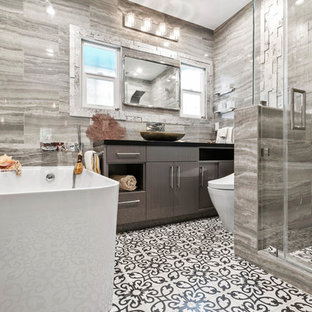 Small beach style master gray tile and porcelain tile cement tile floor and multicolored floor bathroom photo in Los Angeles with flat-panel cabinets, black cabinets, a bidet, gray walls, a vessel sink, quartz countertops and black countertops