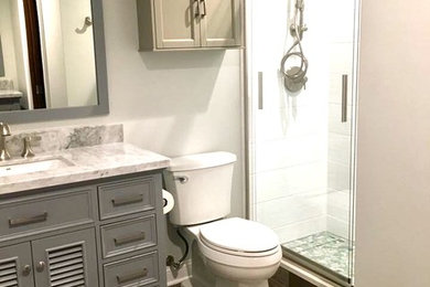 Example of a mid-sized trendy master white tile and ceramic tile ceramic tile and brown floor bathroom design in Chicago with louvered cabinets, a one-piece toilet, gray walls, an undermount sink and marble countertops