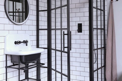 Small industrial bathroom in London with a corner shower, white walls, a pedestal sink and a hinged door.