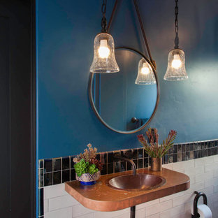 Esempio di una piccola stanza da bagno bohémian con doccia alcova, WC monopezzo, pistrelle in bianco e nero, piastrelle in ceramica, pareti blu, pavimento in terracotta, lavabo da incasso, top in rame, pavimento rosso e porta doccia a battente