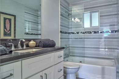 Example of a kids' gray tile porcelain tile, gray floor and single-sink bathroom design in Los Angeles with shaker cabinets, white cabinets, a one-piece toilet, gray walls, an undermount sink, quartz countertops, gray countertops and a freestanding vanity