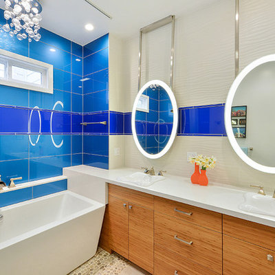 Inspiration for a mid-sized contemporary master blue tile and glass tile pebble tile floor freestanding bathtub remodel in San Francisco with flat-panel cabinets, light wood cabinets, an integrated sink, solid surface countertops and multicolored walls