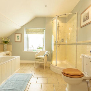 Idee per una stanza da bagno padronale country con vasca da incasso, doccia ad angolo, WC a due pezzi, piastrelle beige, pareti blu, pavimento beige e porta doccia scorrevole