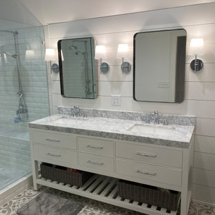 Bild på ett stort vintage grå grått en-suite badrum, med luckor med infälld panel, vita skåp, ett badkar med tassar, en dubbeldusch, ett urinoar, vita väggar, klinkergolv i porslin, ett undermonterad handfat, marmorbänkskiva och dusch med gångjärnsdörr