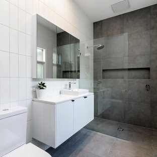 Design ideas for a contemporary 3/4 bathroom in Adelaide with flat-panel cabinets, white cabinets, a curbless shower, a two-piece toilet, gray tile, white walls, concrete floors, a vessel sink, grey floor, an open shower, white benchtops, a niche, a single vanity and a floating vanity.