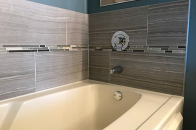 Diseño de cuarto de baño clásico renovado con bañera empotrada, baldosas y/o azulejos grises, baldosas y/o azulejos de porcelana, paredes azules y suelo de baldosas de porcelana
