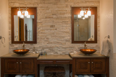 Bild på ett stort lantligt en-suite badrum, med luckor med upphöjd panel, skåp i mörkt trä, ett badkar med tassar, en hörndusch, beige kakel, stenkakel, beige väggar, klinkergolv i keramik, ett fristående handfat, bänkskiva i akrylsten, beiget golv och dusch med gångjärnsdörr