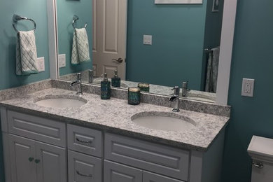 Example of a mid-sized transitional kids' white tile and porcelain tile porcelain tile alcove shower design in Boston with raised-panel cabinets, white cabinets, a two-piece toilet, blue walls, an undermount sink and quartz countertops