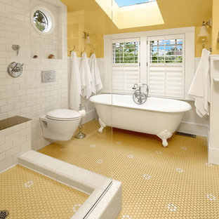 Idéer för ett mellanstort klassiskt beige en-suite badrum, med vita skåp, ett badkar med tassar, en öppen dusch, en vägghängd toalettstol, vit kakel, tunnelbanekakel, gula väggar, plywoodgolv, flerfärgat golv, med dusch som är öppen, ett konsol handfat och granitbänkskiva