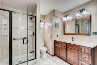 Example of a mid-sized cottage master beige tile alcove shower design in Cleveland with shaker cabinets, medium tone wood cabinets, beige walls, an integrated sink and beige countertops