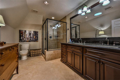 ヒューストンにある中くらいなトランジショナルスタイルのおしゃれなマスターバスルーム (レイズドパネル扉のキャビネット、濃色木目調キャビネット、コーナー設置型シャワー、分離型トイレ、ベージュの壁、セラミックタイルの床、アンダーカウンター洗面器) の写真