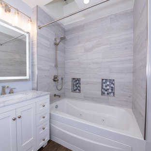 Mid-sized minimalist 3/4 gray tile and porcelain tile cement tile floor, brown floor, single-sink and tray ceiling bathroom photo in Los Angeles with flat-panel cabinets, white cabinets, a hot tub, a one-piece toilet, gray walls, an undermount sink, quartzite countertops, gray countertops, a niche and a built-in vanity