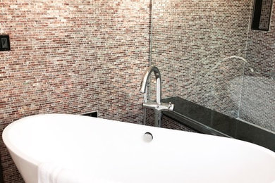 Inspiration for a large modern master multicolored tile and glass tile ceramic tile and multicolored floor freestanding bathtub remodel in Other with a one-piece toilet, white walls and a hinged shower door