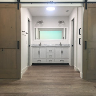 Inspiration for a mid-sized 1960s master white tile and subway tile laminate floor and brown floor alcove shower remodel in Los Angeles with shaker cabinets, white cabinets, a one-piece toilet, gray walls, an undermount sink, marble countertops and a hinged shower door