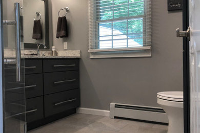 Inspiration for a mid-sized modern master ceramic tile and gray floor alcove shower remodel in Bridgeport with flat-panel cabinets, gray cabinets, a two-piece toilet, gray walls, an undermount sink, quartz countertops, a hinged shower door and gray countertops
