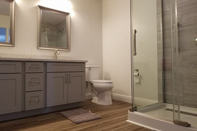 Design ideas for a medium sized classic shower room bathroom in Hawaii with shaker cabinets, brown cabinets, a corner shower, a two-piece toilet, grey tiles, porcelain tiles, white walls, medium hardwood flooring, a submerged sink, granite worktops, brown floors, a sliding door and grey worktops.