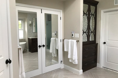Medium sized traditional ensuite bathroom in DC Metro with flat-panel cabinets, brown cabinets, a freestanding bath, an alcove shower, white tiles, metro tiles, grey walls, porcelain flooring, a submerged sink, engineered stone worktops, beige floors and a hinged door.