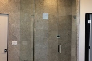 Imagen de cuarto de baño principal moderno de tamaño medio con ducha empotrada, baldosas y/o azulejos grises, baldosas y/o azulejos de porcelana, paredes grises, suelo de cemento, suelo beige y ducha con puerta con bisagras