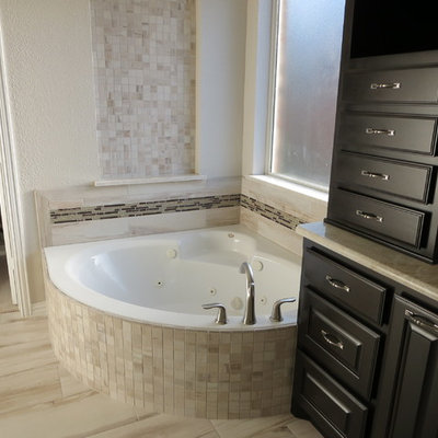 Inspiration for a large timeless master beige tile and porcelain tile porcelain tile bathroom remodel in Dallas with raised-panel cabinets, black cabinets, white walls, solid surface countertops and an undermount sink