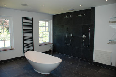 Immagine di una grande stanza da bagno contemporanea con lavabo sospeso, vasca freestanding, doccia doppia, WC sospeso, piastrelle nere, piastrelle in pietra e pavimento in ardesia