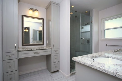 Corner shower - mid-sized transitional master gray tile and porcelain tile porcelain tile corner shower idea in Houston with shaker cabinets, gray cabinets, a two-piece toilet, gray walls, an undermount sink and granite countertops