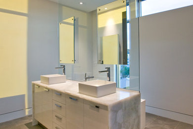 タンパにある高級な広いコンテンポラリースタイルのおしゃれなマスターバスルーム (フラットパネル扉のキャビネット、白いキャビネット、ドロップイン型浴槽、白いタイル、白い壁、ベッセル式洗面器、クオーツストーンの洗面台、ベージュの床、オープン型シャワー、分離型トイレ、セラミックタイルの床、オープンシャワー) の写真