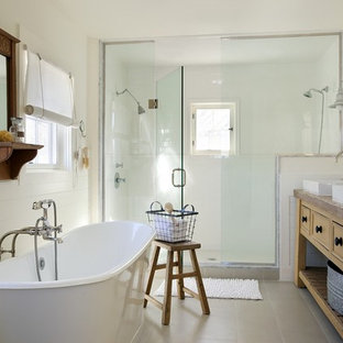 Imagen de cuarto de baño costero con lavabo encastrado, puertas de armario amarillas, bañera exenta y ducha empotrada