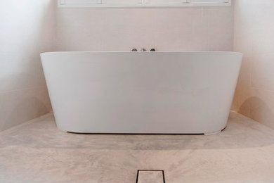 Imagen de cuarto de baño actual con bañera exenta, ducha esquinera, paredes blancas, suelo de cemento y encimera de cemento