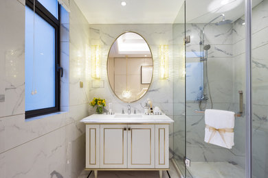 Mid-sized trendy 3/4 white tile and marble tile marble floor and white floor corner shower photo in Los Angeles with recessed-panel cabinets, white cabinets, white walls, an undermount sink, solid surface countertops, a hinged shower door and white countertops