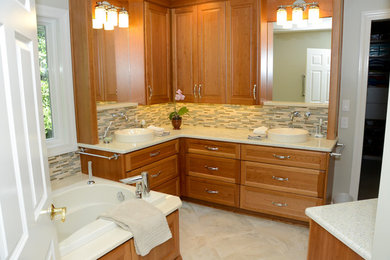 Example of a large trendy master beige tile and porcelain tile porcelain tile bathroom design in St Louis with recessed-panel cabinets, a vessel sink, medium tone wood cabinets, recycled glass countertops, a two-piece toilet and green walls