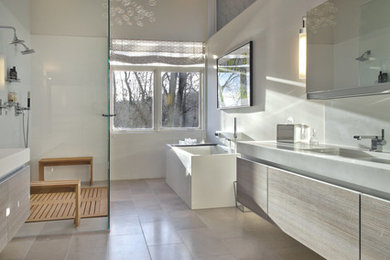 Modelo de cuarto de baño contemporáneo con armarios con paneles lisos, puertas de armario de madera clara, ducha a ras de suelo y paredes blancas