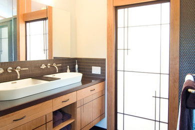Example of a trendy gray tile and mosaic tile bathroom design in San Francisco with a trough sink, flat-panel cabinets, medium tone wood cabinets and beige walls